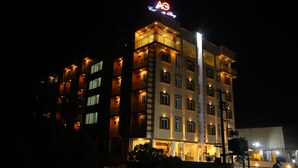 A multi-story hotel with illuminated balconies and a prominent 'AG' sign on the roof. - AG Corporate Stay (Chengalpattu)