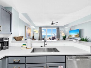 A modern kitchen with a large island, a built-in oven, and a stainless steel sink. - 🏖️Endless Gulf Views-Next To Pier Park-Pools-Hot Tubs-Calypso 3-2003 - Sunset Bl (Panama City Beach)