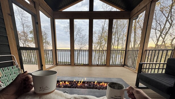 A cozy outdoor seating area with a fire feature, wooden deck, and a view of a body of water. - Amazing 6-bedroom Lakefront Home in Cassopolis, MI (Cassopolis)
