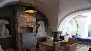 A cozy room with a stone fireplace, wooden furniture, and a view of the outdoors. - AU COCON SAVOIE☃️❄️ Cosy valley accommodation for the clever😃⛷️🏂🏻 (La Plagne Tarentaise)