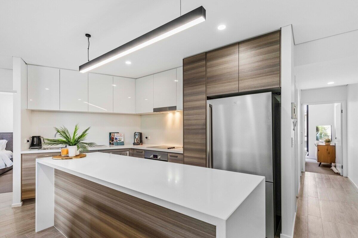 A modern kitchen with a central island, stainless steel appliances, and a minimalist design.