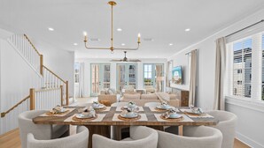 Un'elegante zona pranzo con tavolo in legno apparecchiato per sei persone, circondato da sedie imbottite.