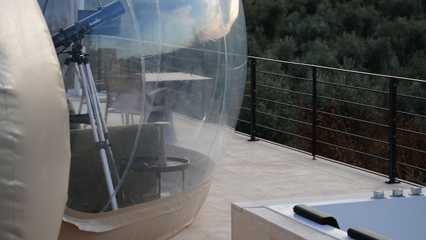 A transparent dome structure with a telescope on a terrace. - Panoramic Suites (Guadamur)