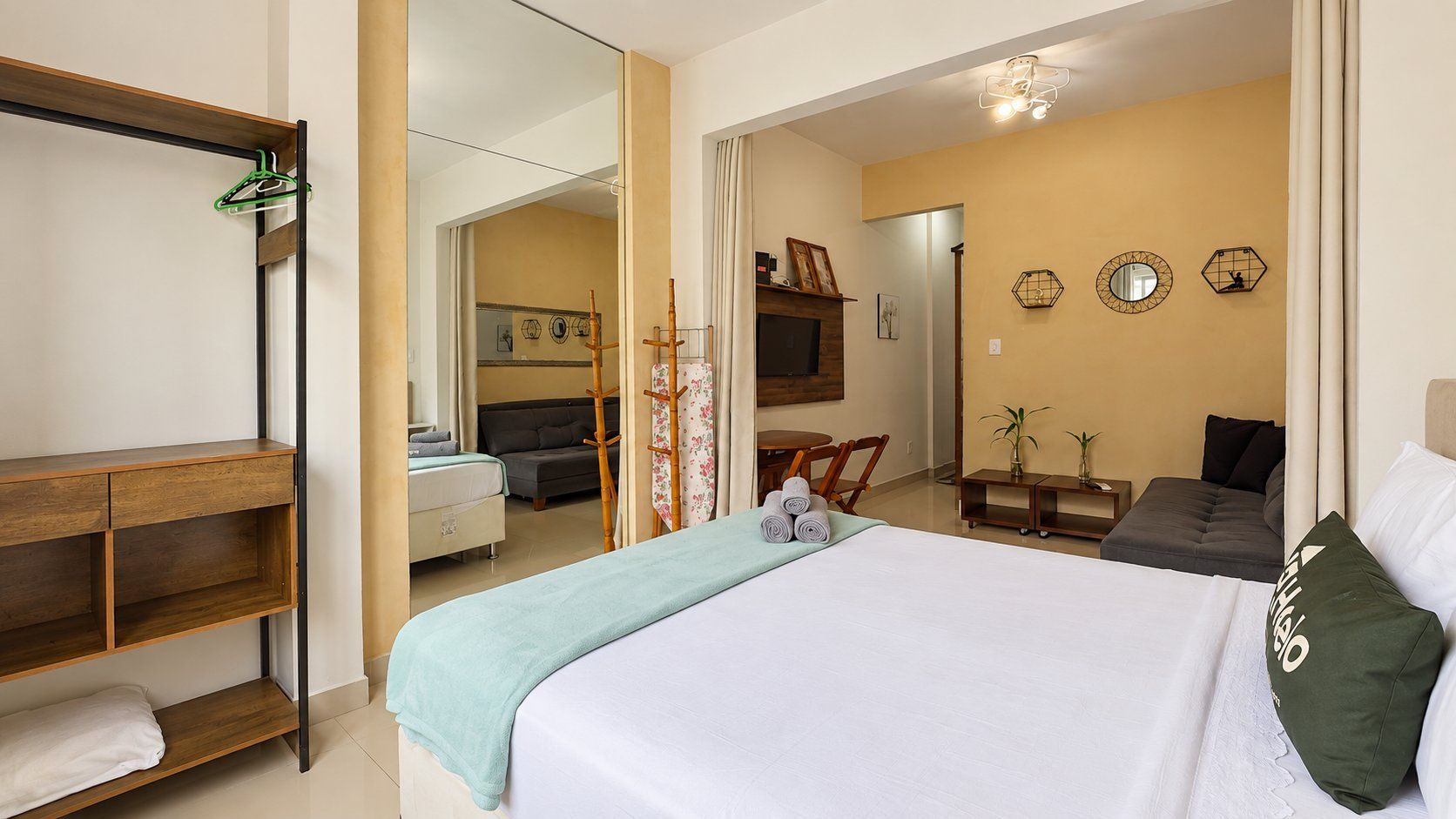 Ein Hotelzimmer mit einem Bett, einer Holzablage, einem Schreibtisch und einer Sitzecke mit einer Couch und Sesseln.
