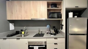 Una cocina moderna con armarios de madera, un refrigerador de acero inoxidable, un microondas y un horno empotrado.