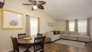 A dining area with a round table and chairs, a ceiling fan, and two framed artworks on the walls. - Beautifully furnished house located in sought after Rosedale community. (Rosedale)