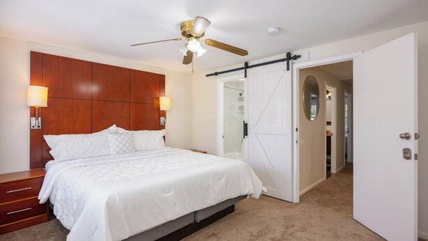 A bedroom with a large bed, a ceiling fan, and a wardrobe. - Beautifully furnished house located in sought after Rosedale community. (Rosedale)