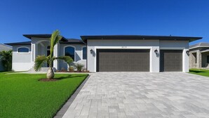 A modern two-story house with a large garage, a well-maintained lawn, and a paved driveway. - Sweet Retreat, Sleeps 6, heated salt pool (Port Charlotte)