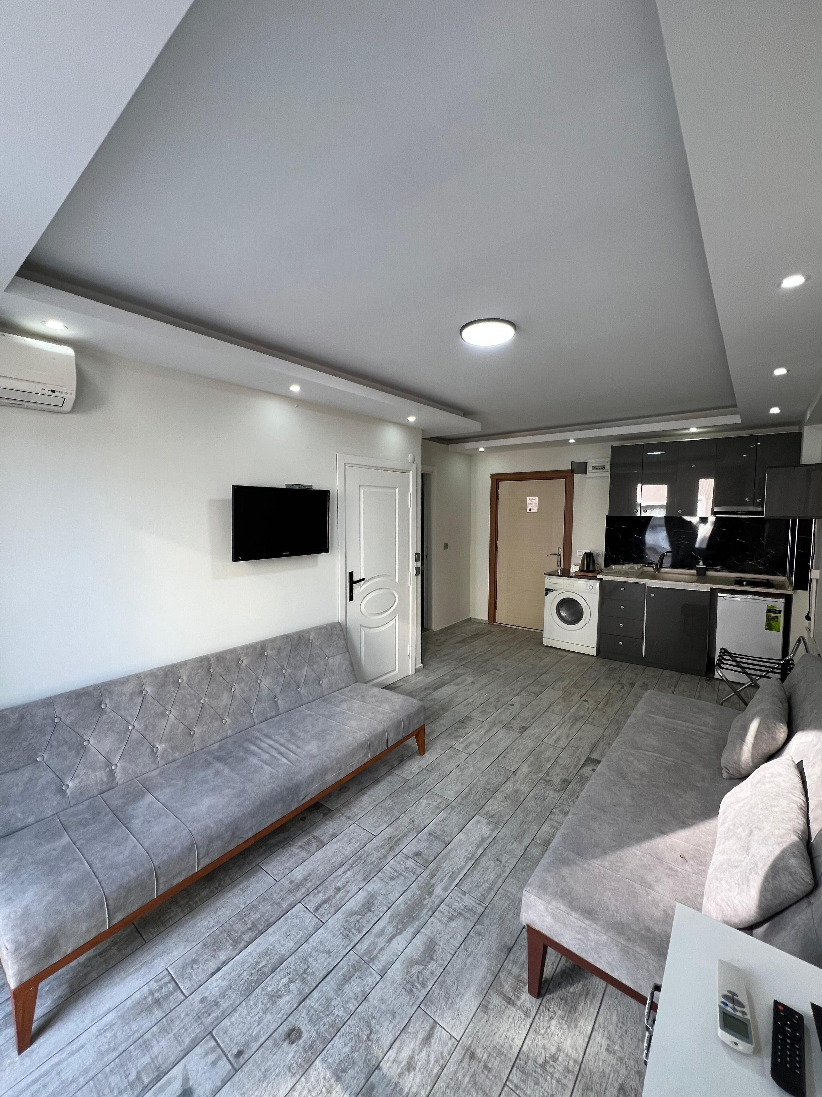 Deluxe Double Room Single Use | Living area | 120-inch Smart TV with satellite channels, video game console, Netflix