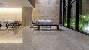 A modern lobby with a minimalist design, featuring a sofa and chairs, a patterned wall, and large windows. - NEW Apartment, best rooftop pool view, Cartagena (Cartagena)