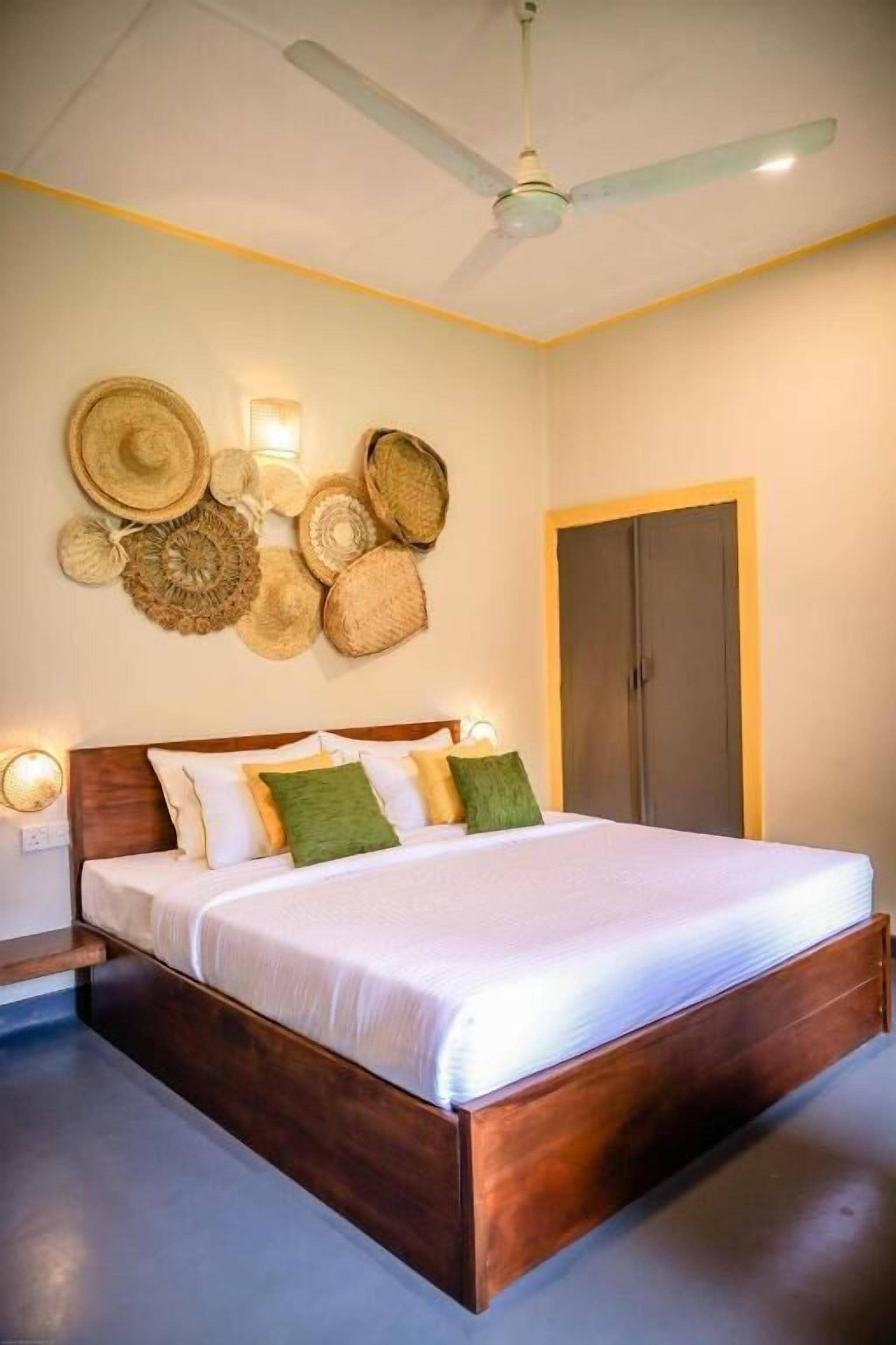 A bedroom with a wooden bed, a ceiling fan, and wall-mounted woven baskets.