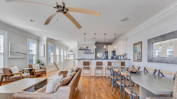 A spacious kitchen with a central island, wooden flooring, and pendant lighting. - Hightide Oasis is a bright, coastal getaway short walk to the beach. (Carolina Beach)