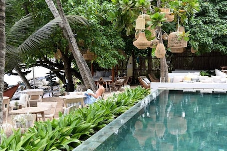 Una piscina al aire libre, sombrillas, sillones reclinables de piscina