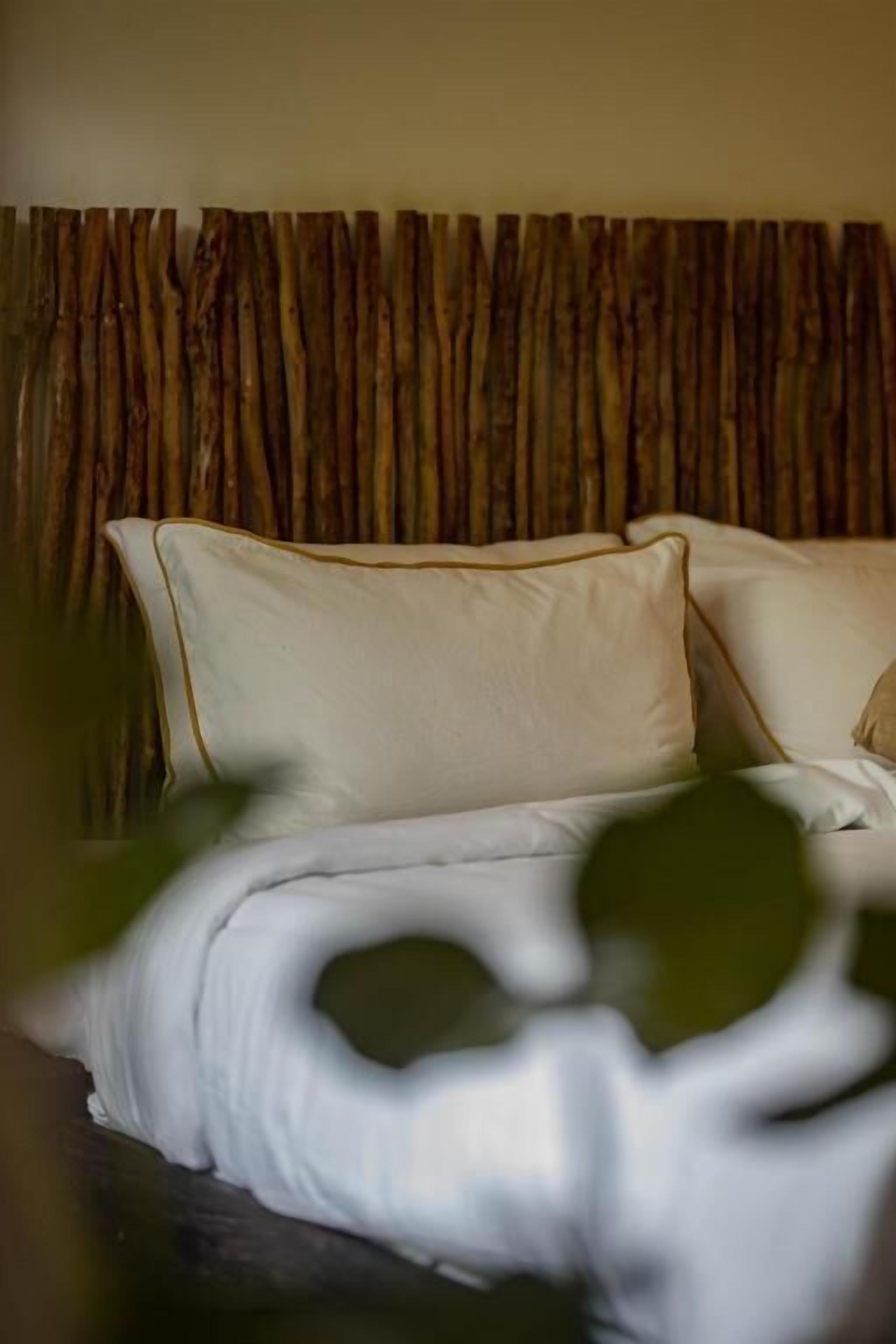 A bed with white bedding and a wooden headboard.