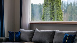Ein modernes Wohnzimmer mit einem grauen Sofa, zwei blauen Kissen und einem Holztisch mit einer blauen Schale.