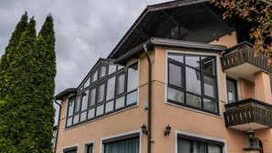 Ein mehrstöckiges Gebäude mit großen Fenstern und einem Balkon.