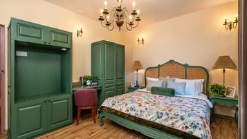 Un dormitorio con una cama grande, un armario verde y una araña.