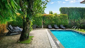 A swimming pool with lounge chairs and a paved walkway. - Clove Villa Kandy (Kandy)