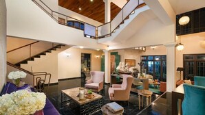 A spacious, multi-level interior with a staircase, seating areas, and a kitchen. - Clove Villa Kandy (Kandy)