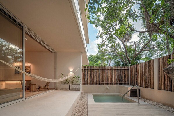 A modern outdoor patio with a pool, a hammock, and a wooden fence. - Greta Luxury Design: Private Pool, Beachfront Bliss in Puerto Morelos! (Puerto Morelos)