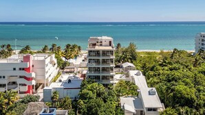 A coastal building with multiple balconies overlooking the sea. - Modern Seafront Unit | Infinity Pool, Gym (Puerto Morelos)
