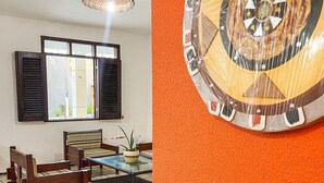 Un comedor con una mesa y sillas de madera, una planta en maceta y un adorno en la pared.