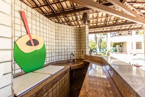 A kitchen with a tiled backsplash, a sink, and a countertop.