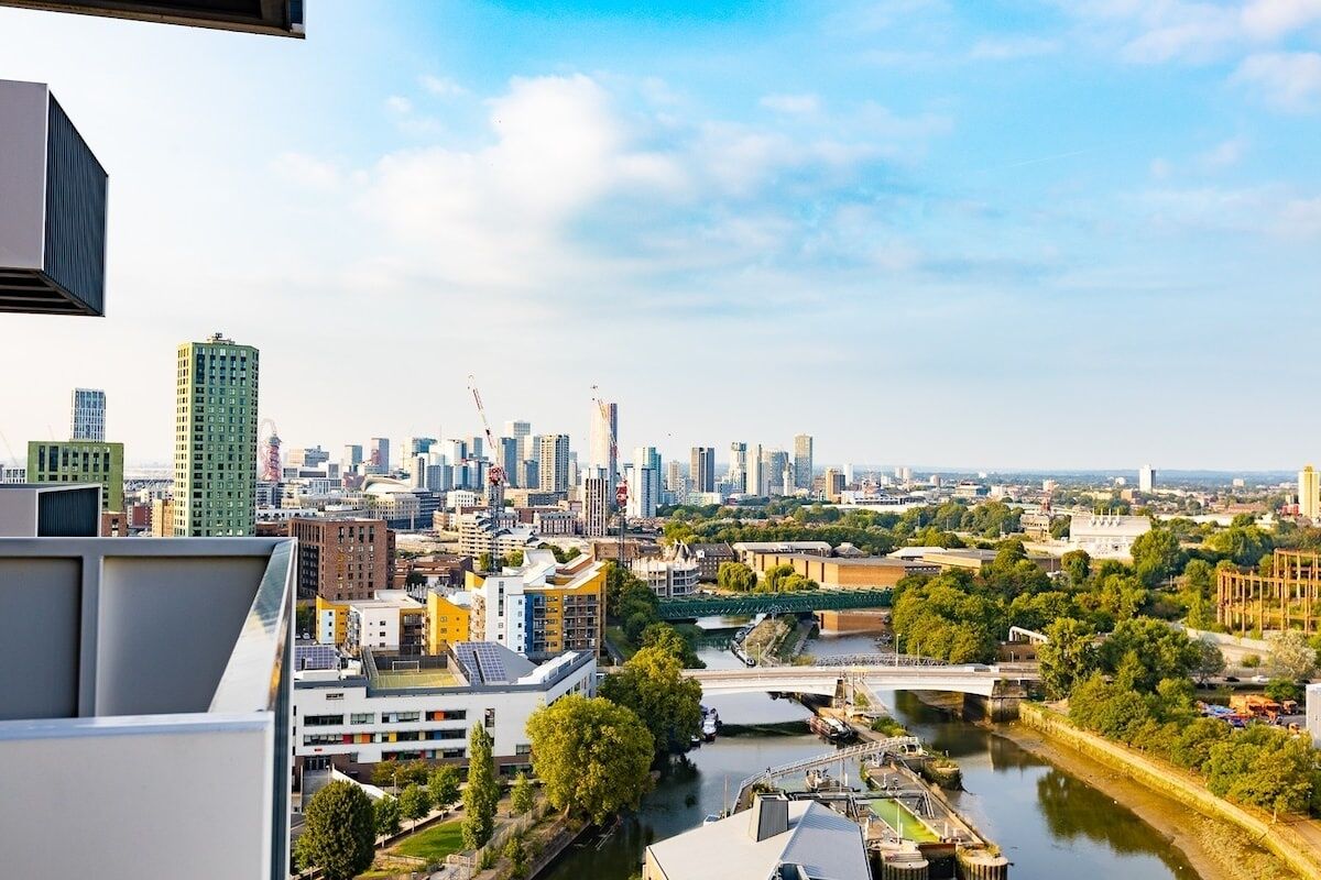 A cityscape with a river, buildings, and a bridge.