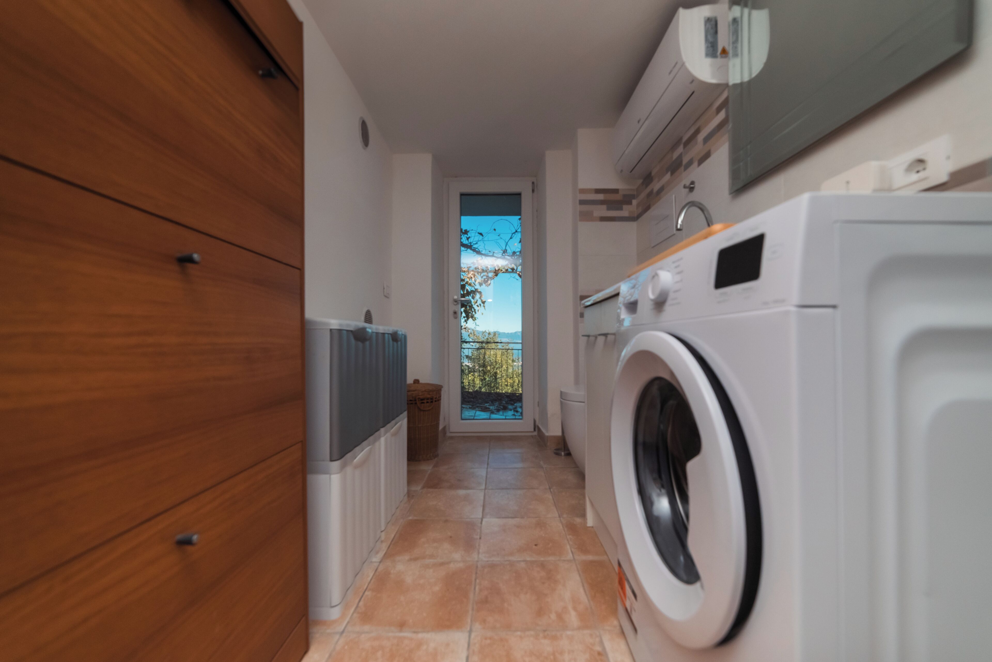 A laundry room with a washing machine, a dryer, and a wooden cabinet.