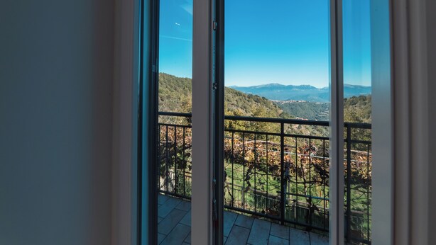 Een balkon met een helder uitzicht op een bergachtig landschap.