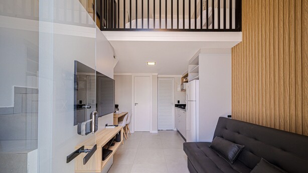 Een moderne woonkamer met een bank, een televisie en een houten kast.