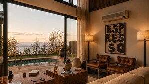 A modern living room with a pool, leather furniture, and a large window with a view of the sea. - Voger Sapanca Lake View (Sapanca)