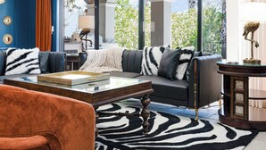 A modern living room with a sofa, coffee table, and a zebra-patterned rug. - Hollywood Glam Villa w/ AGT Stage Arcade Pool Spa! (Kissimmee)