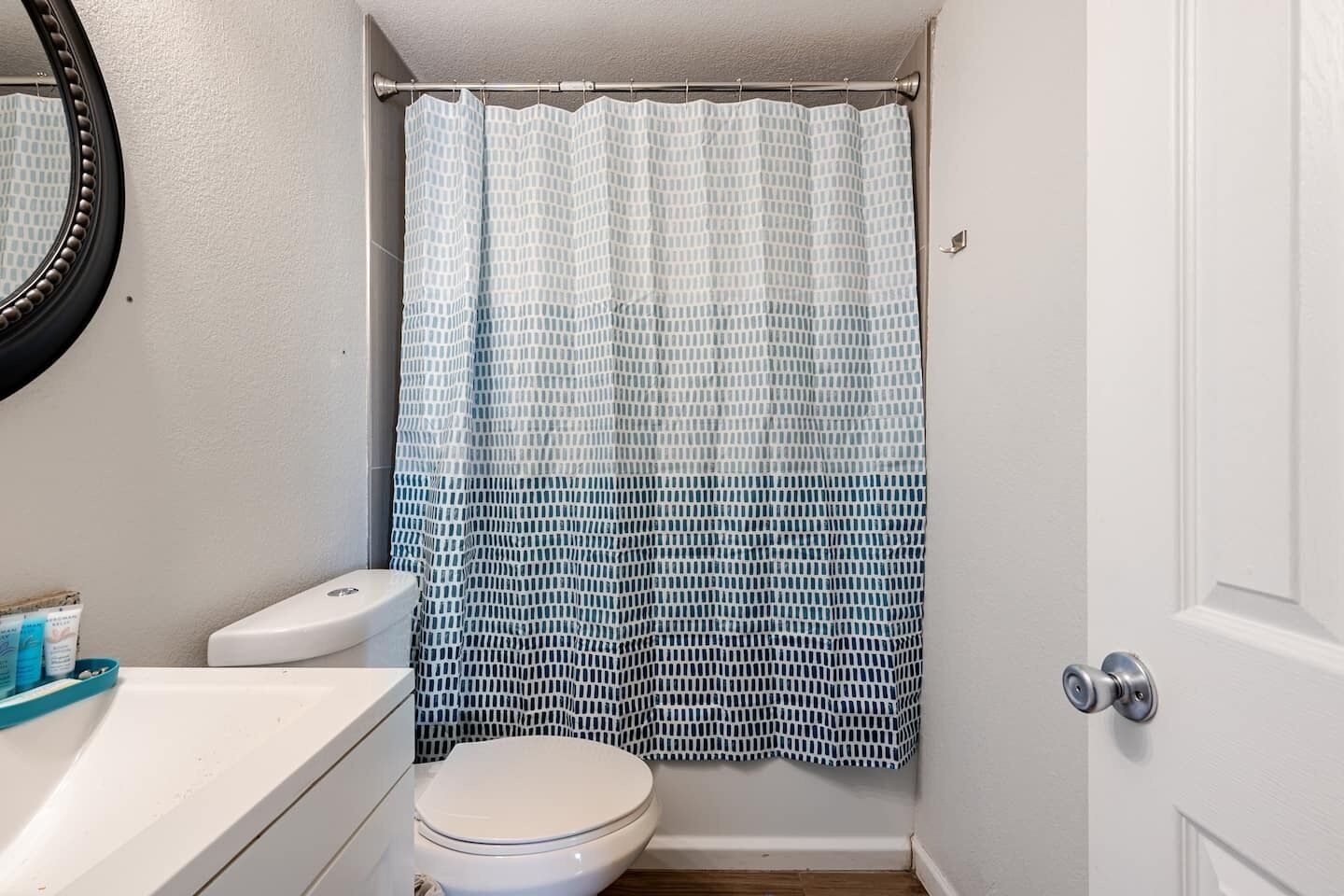 A small bathroom with a toilet, a sink, and a shower curtain.