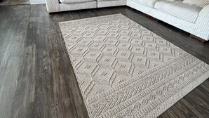 Una sala de estar moderna con un amplio sofá modular y un tapete estampado.