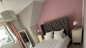 A bedroom with a large bed, a nightstand, a dresser, a mirror, and a window with curtains. - Spacious and pleasant (Garges-lès-Gonesse)