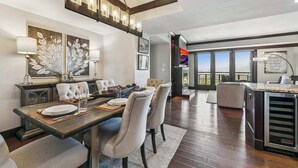 A dining area with a wooden table, chairs, and a chandelier. - Northstar Resort Mid-Mountain Ski in/Ski in/Ski out 3 bedroom condo (Truckee)