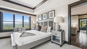 A bedroom with a large window, a bed, bedside tables, and a view of the outdoors. - Northstar Resort Mid-Mountain Ski in/Ski in/Ski out 3 bedroom condo (Truckee)