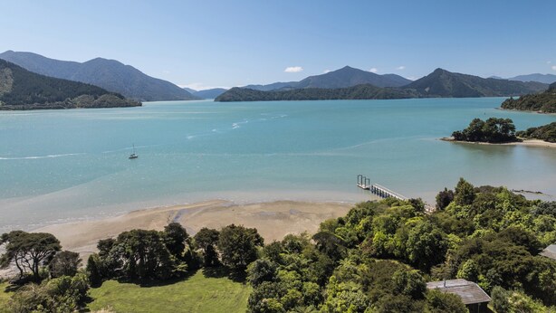 A coastal landscape with a bridge, clear waters, and forested hills. - Kereru Retreat at Moetapu Bay (Moetapu Bay)