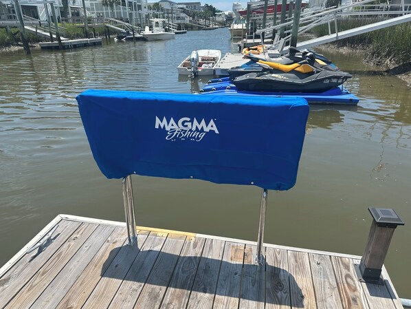 Un quai en bois recouvert d’une housse bleue de la marque MAGMA Fishing USA.