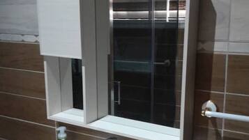 Une salle de bain avec un lavabo blanc, un miroir et un porte-serviettes.