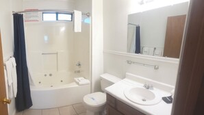 Ein Badezimmer mit Badewanne, Toilette, Waschbecken und Spiegel.