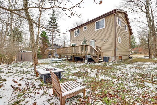 A two-story house with a deck, a covered patio, and a small outdoor seating area with a bench and table. - Ski, Swim & Hike! Family Home in Tobyhanna (Tobyhanna)