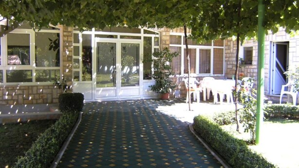 A covered outdoor area with a patterned floor, potted plants, and outdoor seating. - Elez Serenity Guesthouse - Twin room 7 (Medugorje)