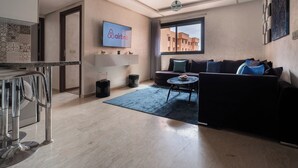 Un salon moderne avec un canapé, une table basse et un téléviseur affichant le logo d’Airbnb.