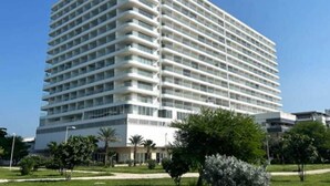 A multi-story hotel with a uniform exterior, balconies on each floor, and a flat roof. - VACATION SUITES /CARTAGENA BEACH RESORT (cartagena)