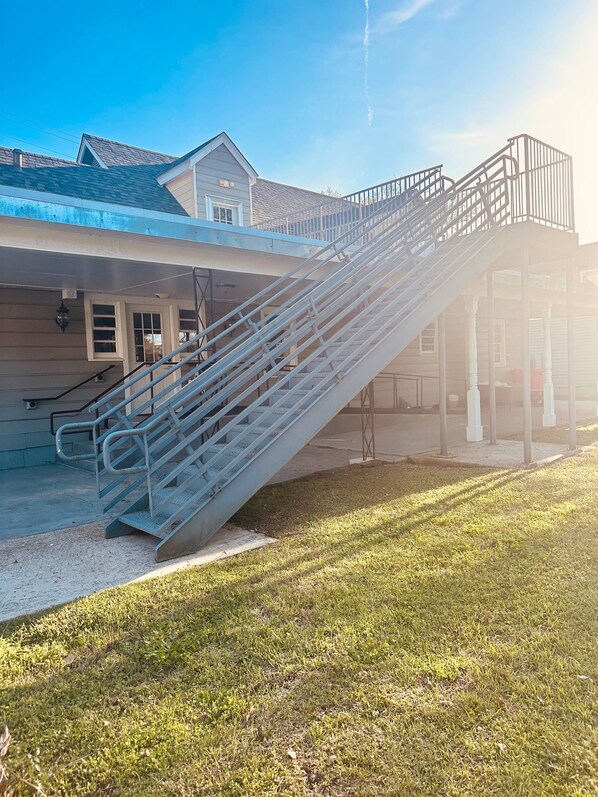 A staircase leading to a covered area with a building in the background. - Cozy loft in Olde Town Slidell (Slidell)