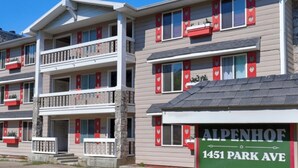 Monikerroksinen hotelli, jossa on parvekkeet, ja sen yläpuolella on kyltti, jossa lukee: ”ALPENHOF 1451 PARK AVE”.