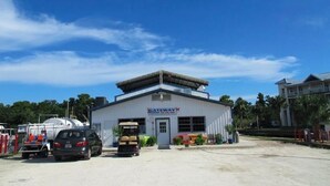 A building with a sign reading 'Gateway' and a covered parking area with vehicles. - Waterfront, Private dock for 4 boats, Sleeps 13+, Fire Pit, Movie Projector. (Old Town)