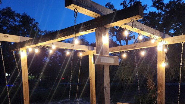 A wooden pergola with string lights and two wooden swings. - Waterfront, Private dock for 4 boats, Sleeps 13+, Fire Pit, Movie Projector. (Old Town)